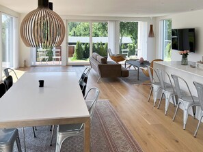 A modern kitchen with a dining area, large windows, and a TV. - 6 Person Holiday Home in Hornbaek (Hornbaek)