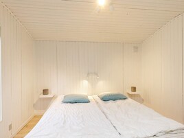 Una habitación con una cama individual, dos mesitas de noche y una lámpara en el techo.