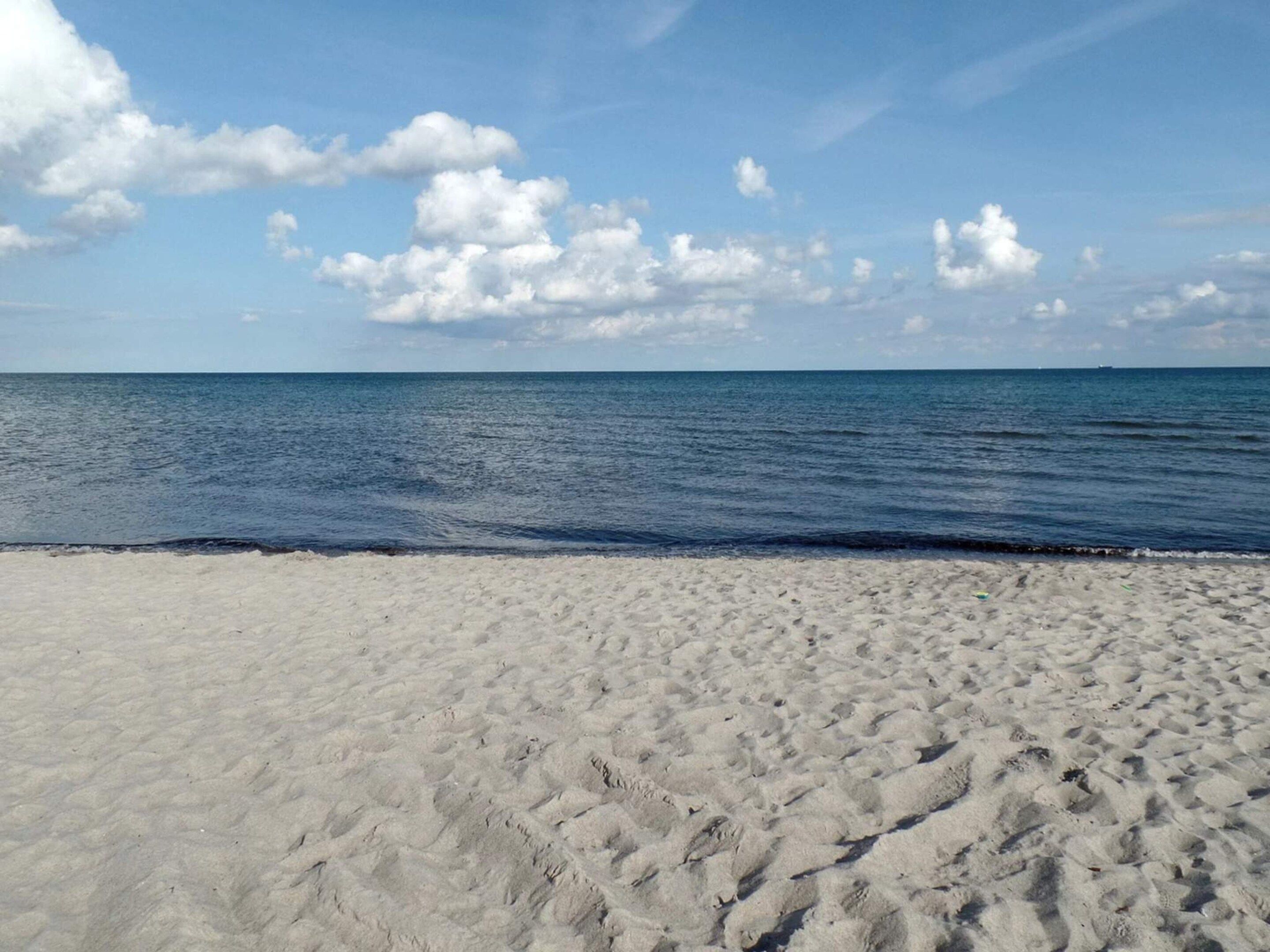 A beach with a clear sky and calm sea.