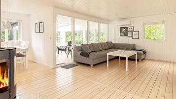 A modern living room with a sectional sofa, a coffee table, and a fireplace.