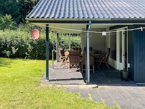 A covered patio with outdoor seating, a brick wall, and a metal roof. - 6 Person Holiday Home in Ansager (Ansager)