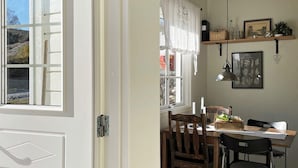 A dining area with a table, chairs, and a window with curtains. - 6 Person Holiday Home in Hoviksnas (Höviksnäs)