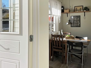 A dining area with a table, chairs, and a window with curtains. - 6 Person Holiday Home in Hoviksnas (Höviksnäs)