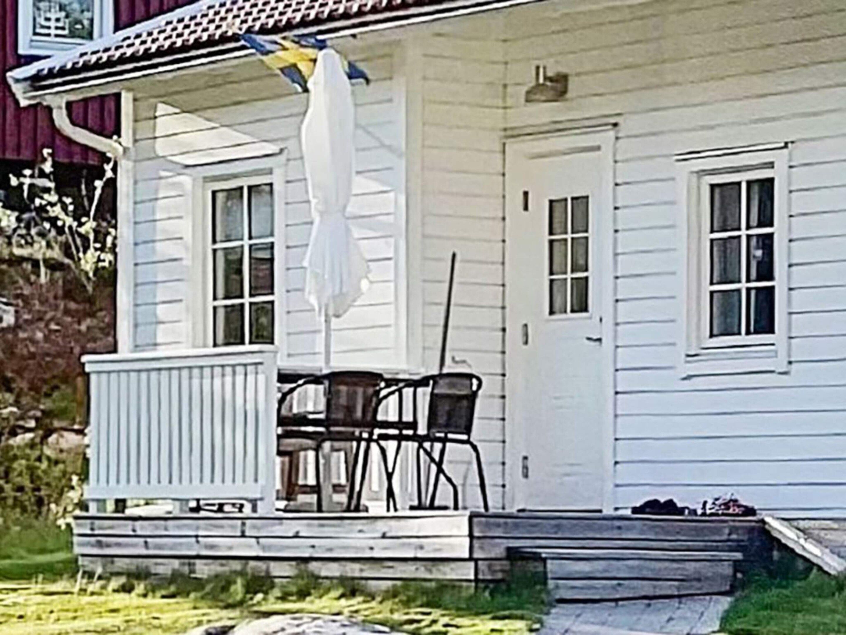 A white house with a covered porch, a door, and a window.