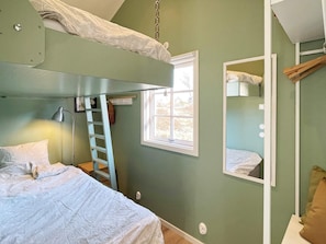 A bunk bed room with a ladder, a window, and a mirror. - 6 Person Holiday Home in Hoviksnas (Höviksnäs)