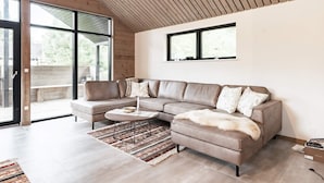 Una sala de estar moderna con un sofá seccional, una mesa de centro y una alfombra estampada.