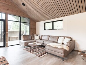 A modern living room with a sectional sofa, a coffee table, and a patterned rug.