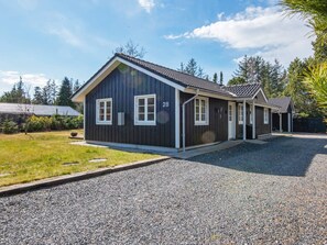 En toetagers bygning med mørkt ydre og hvide detaljer, hvor nummer '28' er angivet på siden.