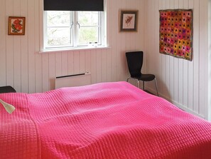 A room with a bed, a chair, a window, and a radiator. - 4 Star Holiday Home in Logstor (Logstor)