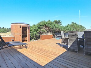 A wooden deck with outdoor furniture, a sauna, and a view of trees. - 6 Person Holiday Home in Blavand (Blavand)