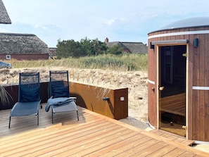 A wooden deck with two lounge chairs, a sauna, and a view of the beach. - 6 Person Holiday Home in Blavand (Blavand)