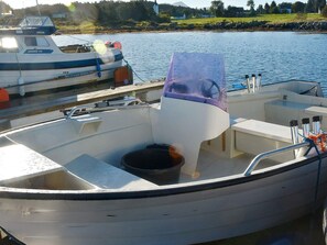 A boat docked at a marina with a cabin, a steering wheel, and a small deck area. - 9 Person Holiday Home in Fjortoft (Ålesund)