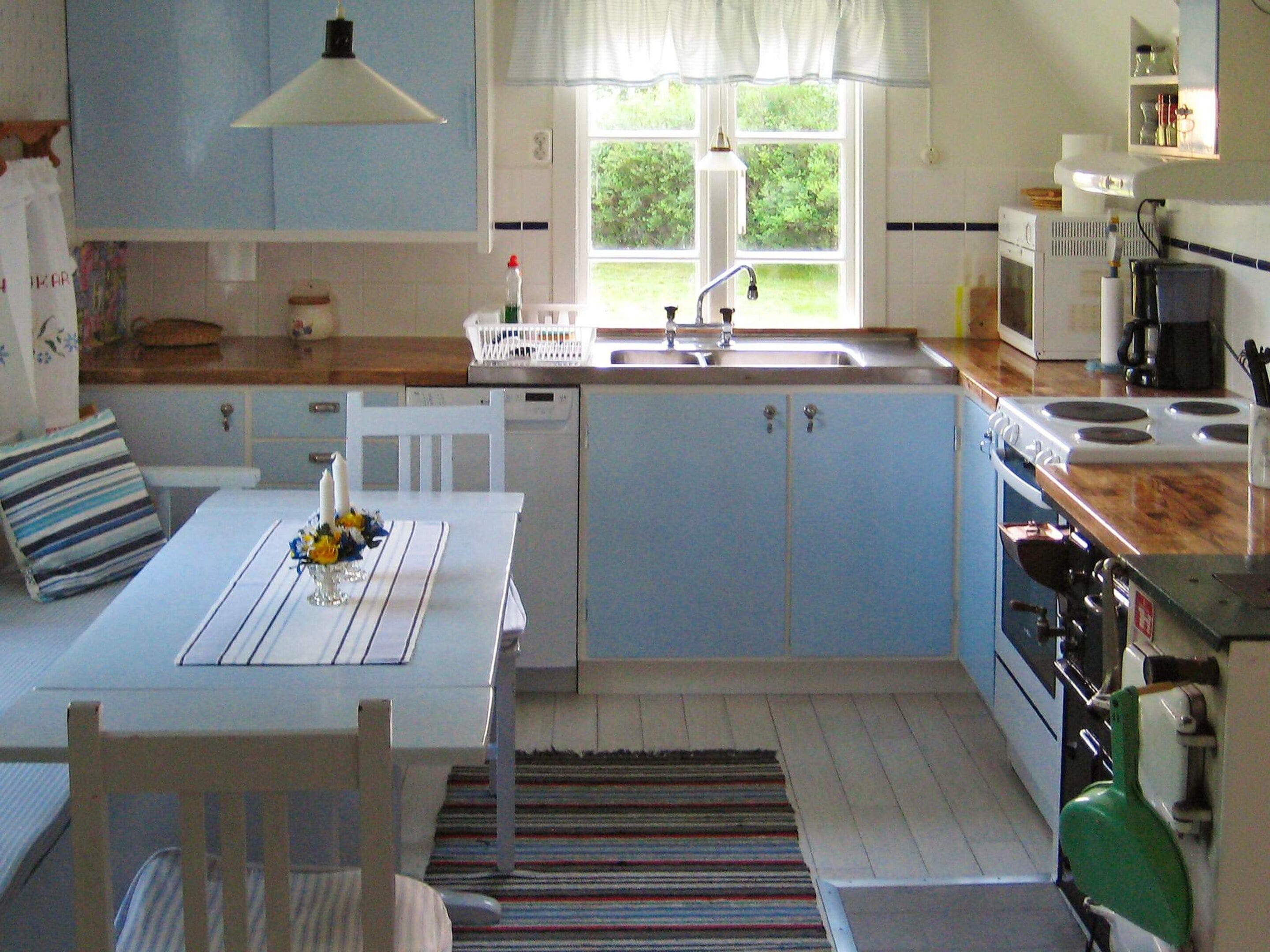 A compact kitchen with a dining area, a window with a view, and a stove.