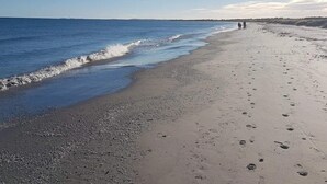 A beach with a clear sky, calm sea, and footprints on the sand. - 6 Person Holiday Home in Albaek (Aalbaek)
