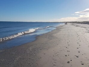 A beach with a clear sky, calm sea, and footprints on the sand. - 6 Person Holiday Home in Albaek (Aalbaek)