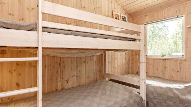 A bunk bed room with wooden walls and a window. - 6 Person Holiday Home in Albaek (Aalbaek)
