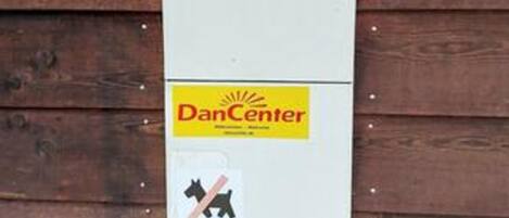 Valkoinen tausta, jossa on keltainen ja punainen logo, musta hevosen siluetti ja teksti »DanCenter».