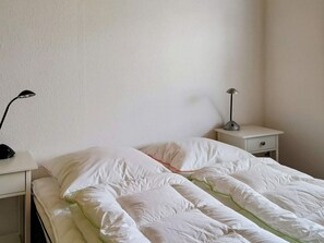 A bedroom with a bed, two bedside tables, and two lamps. - 6 Person Holiday Home in Hojby (Hojby)