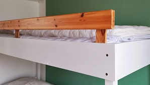 A bunk bed with a wooden headboard and white bedding. - 6 Person Holiday Home in Hojby (Hojby)