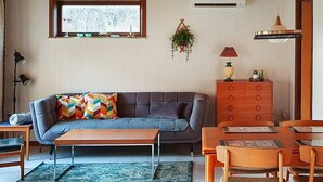 A living room with a sofa, coffee table, and dining area with chairs. - 6 Person Holiday Home in Hojby (Hojby)