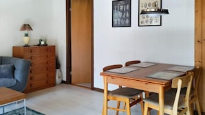 A dining area with a wooden table, four chairs, and two framed botanical prints on the wall. - 6 Person Holiday Home in Hojby (Hojby)
