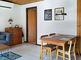 Un comedor con una mesa de madera, cuatro sillas e ilustraciones botánicas enmarcadas en la pared.