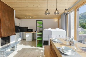 A modern kitchen with a fireplace, wooden ceiling, and a dining area with a view. - Residence de Lognan- Les Jorasses 27, Argentière (Chamonix), France (Argentière (Chamonix))
