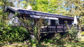 A modern house with a sloped roof, large windows, and a satellite dish.