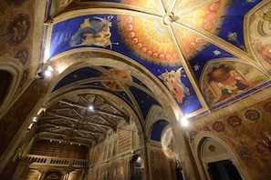 An interior with arched ceilings and detailed frescoes.