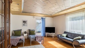 A room with a bed, a sofa, a TV, and a window. - Apartment "Am Hirnach 2" with Shared Garden & Wi-Fi (Sindelfingen)