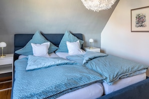 A bedroom with a bed, bedside tables, a chandelier, and a framed artwork on the wall. - Apartment 'Ferienwohnung Trixi' with Shared Garden, Balcony and Wi-Fi (Sexau)