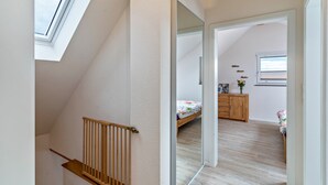 Une chambre à coucher avec un lit en bois, une commode et une fenêtre.