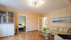 Ein modernes Wohnzimmer mit einer Couch, einem Glastisch und Holzboden.