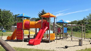 A playground with a slide, climbing net, and various play structures. - 8 Person Holiday Home in Struer (Struer)