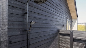 A modern outdoor shower attached to a wooden deck. - 8 Person Holiday Home in Hirtshals (Hirtshals)