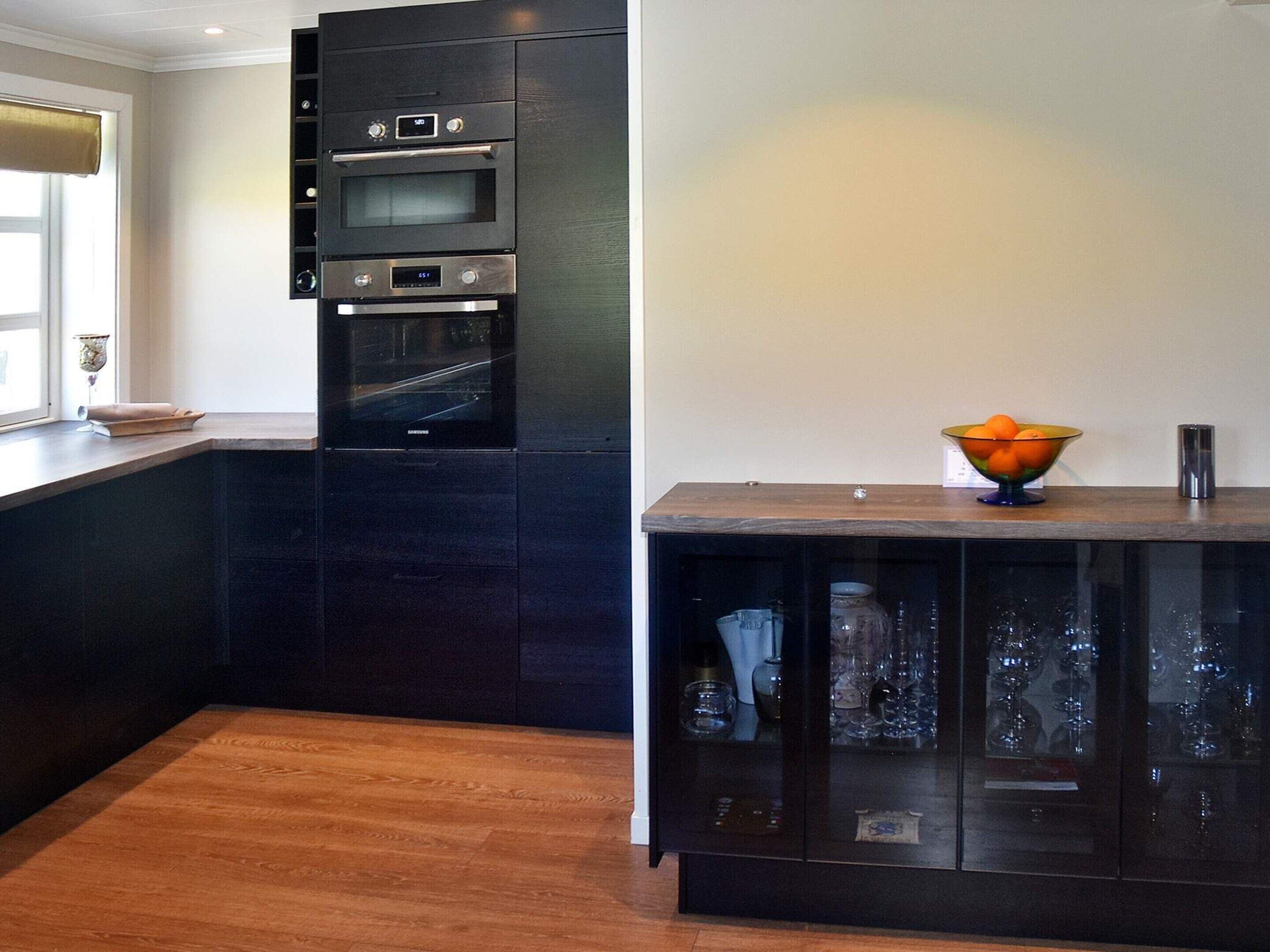 Een moderne keuken met inbouwovens en donkere kastjes.