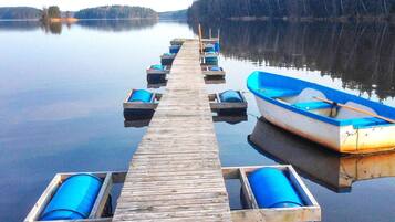 A wooden pier extending into calm water with boats docked at the end.
