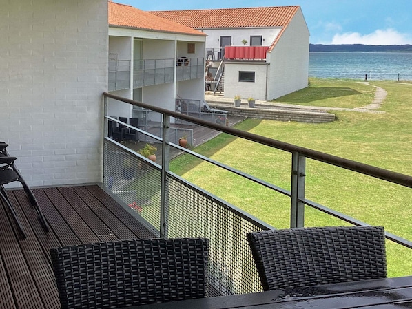 A balcony with a view of a building and a body of water. - 6 Person Holiday Home in Ebeltoft (Ebeltoft)