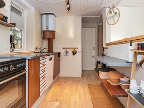 A compact kitchen with a stove, sink, and wooden cabinets. - 6 Person Holiday Home in Silkeborg (Silkeborg)