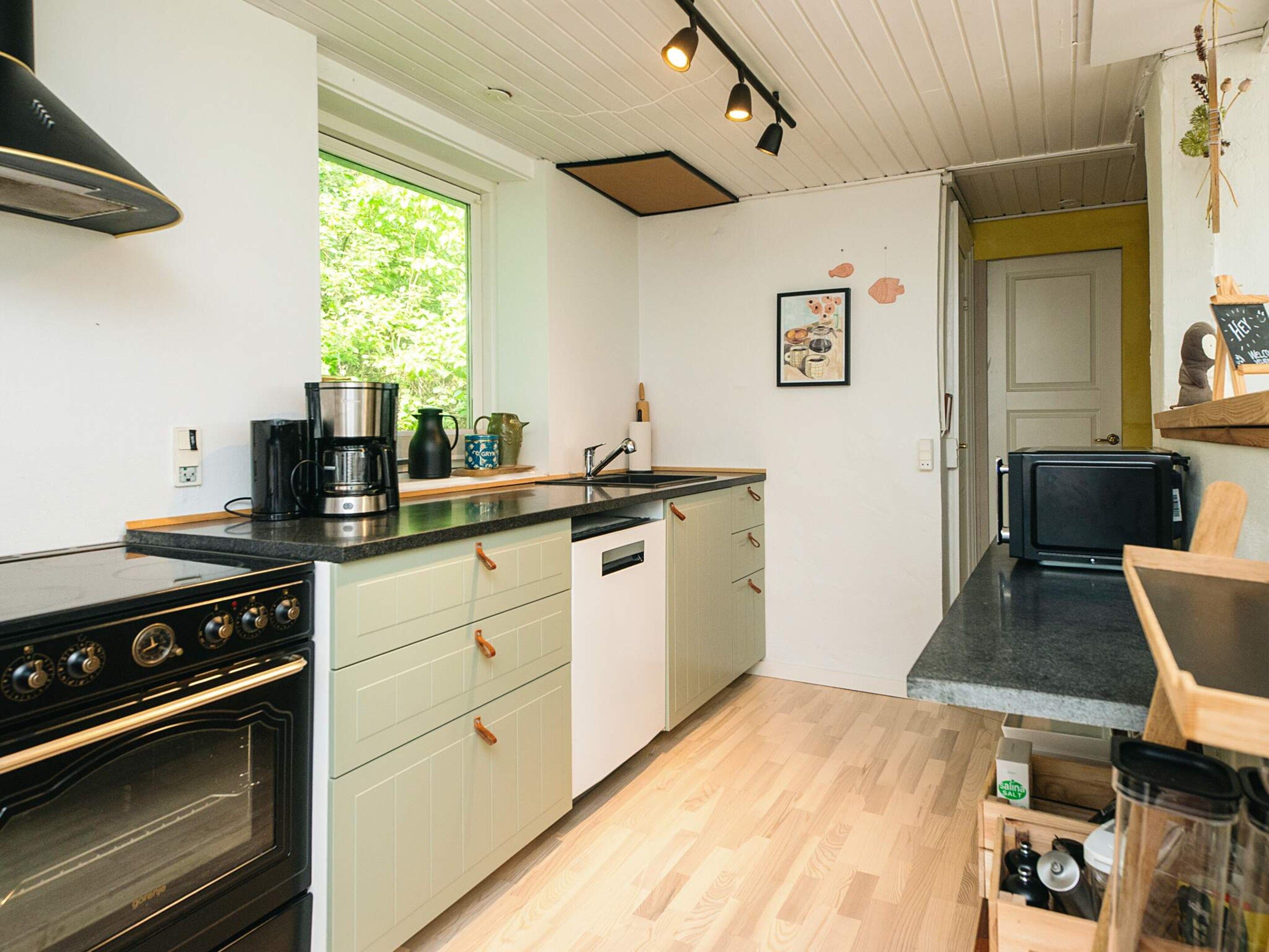 A compact kitchen with a stove, oven, and coffee maker.