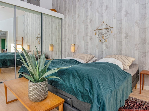 A modern bedroom with a large bed, a mirror, and a wall-mounted light fixture. - 6 Person Holiday Home in Silkeborg (Silkeborg)