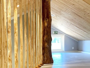 A spacious interior with a high ceiling and a large wooden tree trunk in the foreground. - 4 Star Holiday Home in Sandhem (Sandhem)