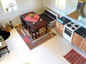 A kitchen with a dining table, chairs, a stove, and a microwave.