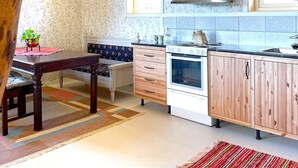 Une cuisine équipée d’une table à manger, d’un banc, d’une cuisinière et d’armoires en bois.