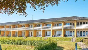 Ein mehrstöckiges Hotel mit Ziegelverkleidung, Balkonen und einem gepflegten Rasen.