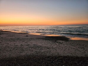 A beach with waves at sunset.