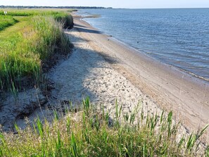 A beach with sand and grass, a clear sky, and a calm sea. - 8 Person Holiday Home in Romo (Rømø)