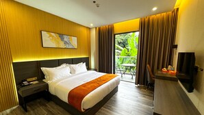 A hotel room with a large bed, a desk, a chair, and a TV. - Venus Royale Hotel (Coron)