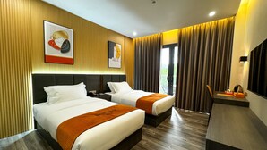 A hotel room with two beds, wooden flooring, and a balcony with curtains. - Venus Royale Hotel (Coron)