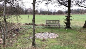 A park with a circular stone pattern, a wooden bench, and trees. - 6 Person Holiday Home in Bedsted Thy (Bedsted)
